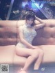 A woman in a silver dress sitting on a couch.