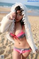 A woman in a bikini standing on a beach.