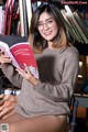 A woman sitting on a chair reading a book.